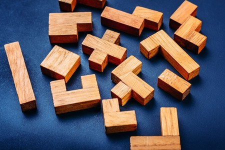 Different geometric shapes wooden blocks on dark background. Creative, logical thinking and problem solving conceptの写真素材