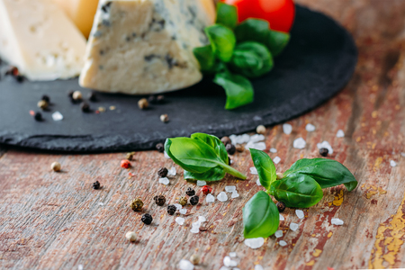 Close up of fresh basil leaf, cheese and spices on wooden backgroundの写真素材