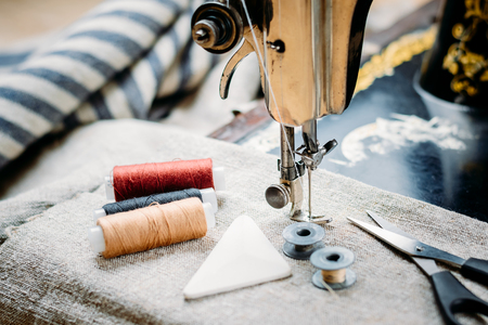 Old vintage hand sewing machine, sewing tools and accessories close upの写真素材