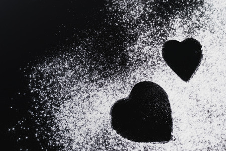 Baking background with heart shape and flour on dark table with copy space, top viewの写真素材
