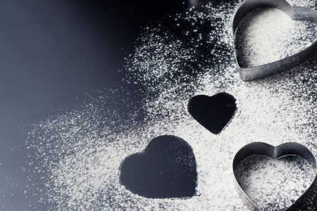 Baking background with heart shape and flour on dark table with copy space, top viewの写真素材