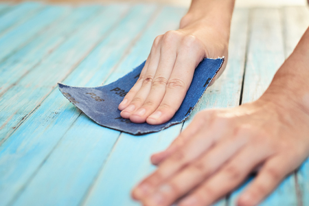 Hands polishing wooden boards with sandpaperの写真素材