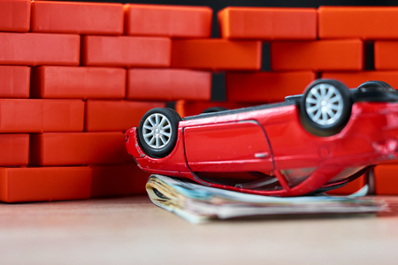 Car insurance concept. Broken car and pile of usd banknotesの写真素材