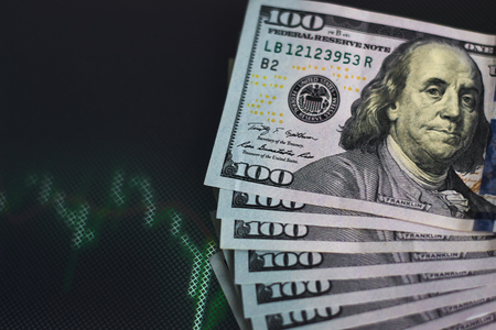 US dollar bills on background with dynamics of exchange rates. Trading and financial risk conceptの写真素材