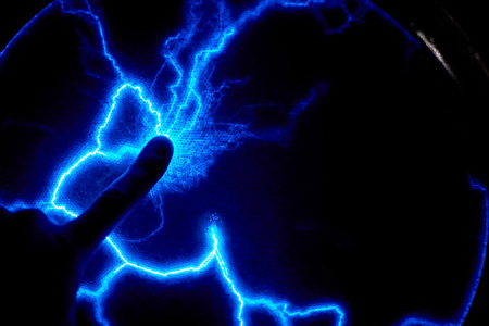 Finger touch electric plasma ball on dark background. Static electricity model