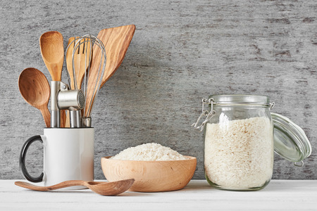 Kitchen utensils and glass jar with rice on gray wall backgroundの写真素材