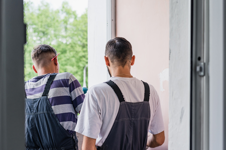 Process male worker repairing window in house, close upの写真素材