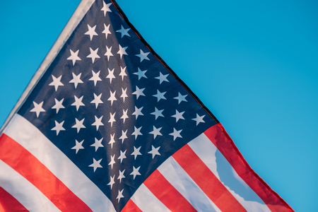American flag in blue sky. close up. Symbol of Independence Day fourth of July in USAの写真素材
