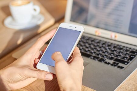 Women hold smartphone during coffee break in cafe