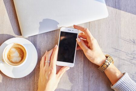 Women hold smartphone during coffee break in cafeの写真素材
