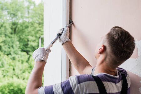 Process male worker repairing window in house, close upの写真素材