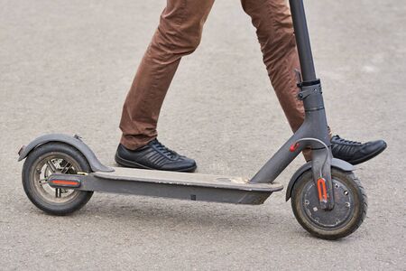 Close up of man driving on electric scooter in cityの写真素材