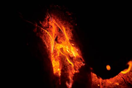 Close up of bonfire with sparks at night. Heat from burning logs and coals in the darkの写真素材