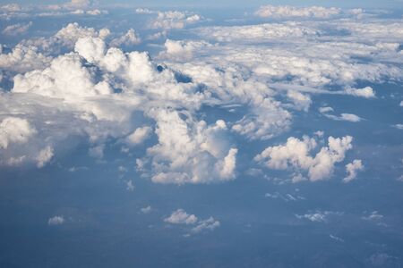 Blue cloudy sky, view from airplane window. Aerial view of cloudscape