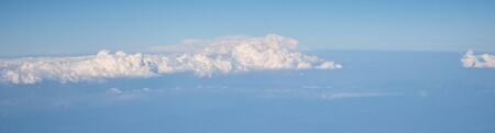 Aerial view of fluffy clouds. Top view of beautiful cloudscape and blue sky, long bannerの写真素材
