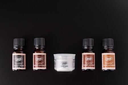 Dobrush, Belarus - October 27, 2019: natural henna powder in bottles and eyelash brush on dark...