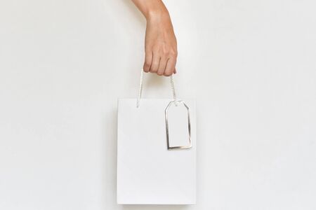 woman hand hold paper shopping bag on white background, close upの写真素材