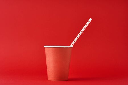 Red paper coffee cup with straw on red background. Minimalism styleの写真素材