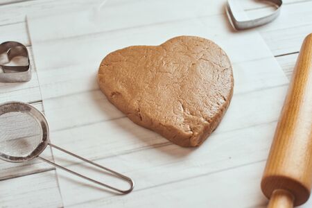 raw dough in shape of heart on tableの写真素材