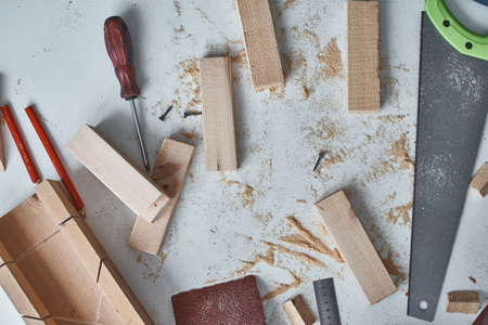 DIY concept. Work table with carpenter tools and cropped wooden planks, top view.