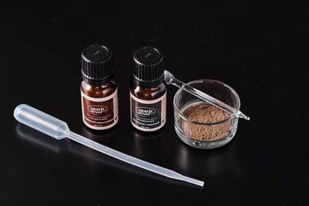 Dobrush, Belarus - October 27, 2019: natural henna powder in bottles and eyelash brush on dark backgroundのeditorial素材