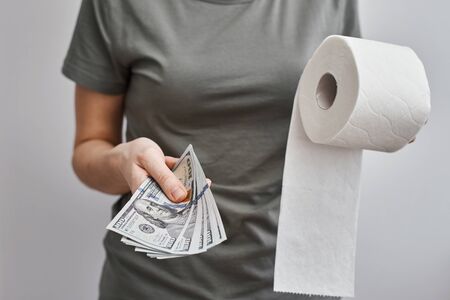 Woman buy toilet paper roll. Coronavirus covid-19 panic concept, stocking up toilet paper for home quarantineの写真素材