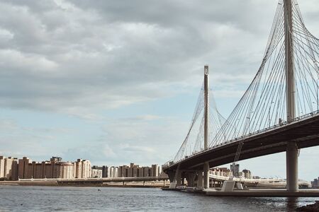 modern cable stayed bridge over the river against cloudy sky. Engineering construction close upの写真素材