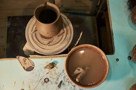 Clay pot on a potter's wheel in workshop interior