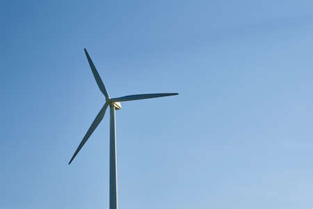 Wind turbine against blue sky. Wind power energy concept. Renewable energy for climate protectionの写真素材
