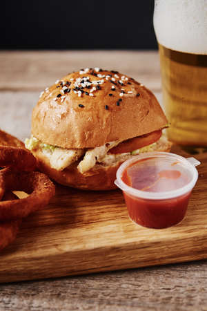 Glass of beer and snacks on wooden table on a dark backgroundの写真素材
