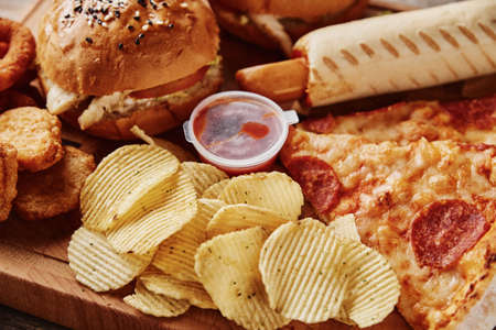 Unhealthy and junk food. Different types of fastfood and snacks on the table, close up. Takeaway foodの写真素材