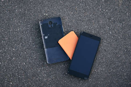 Damaged smartphone with broken touch screen on the asphaltの写真素材