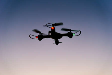 Drone quad copter toy against sunset sky