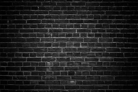 Black wall brick background with vignettingの写真素材