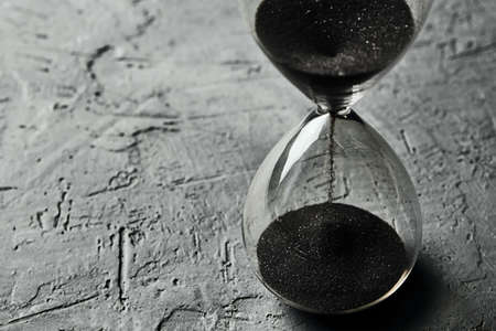 Hourglass on dark background, close up. Urgency and running out of time conceptの写真素材