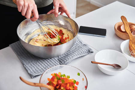 Woman in the kitchen cooking a cake. Hands beat the dough with mixer