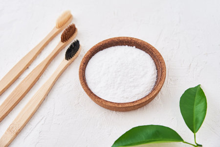 Three wooden bamboo toothbrushes and baking soda on a white background, top view. Eco friendly toothbrushes, zero waste conceptの写真素材