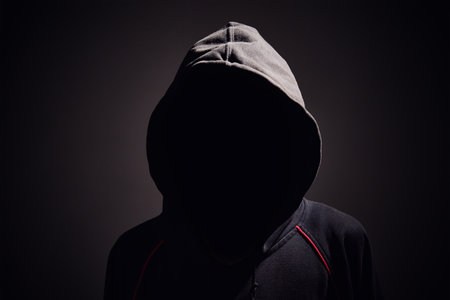 Silhouette af man without face in hood on a black background. Anonymous crime conceptの写真素材