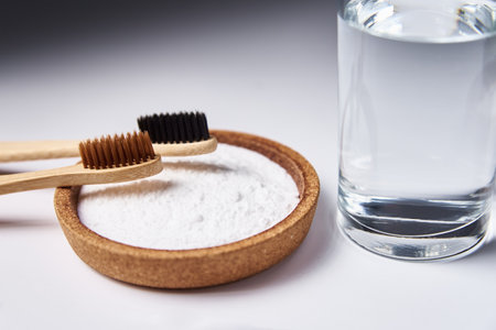 Bamboo toothbrushes, baking soda and glass of water on a white background. Eco friendly toothbrushes, zero waste conceptの写真素材