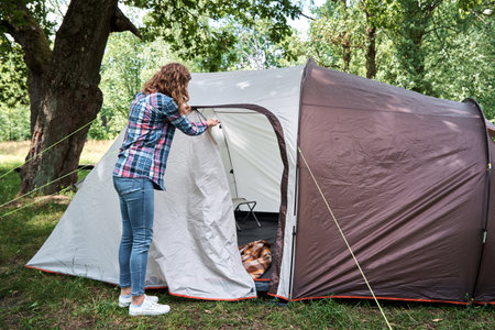 Woman setting up a camping tent at forestのeditorial素材