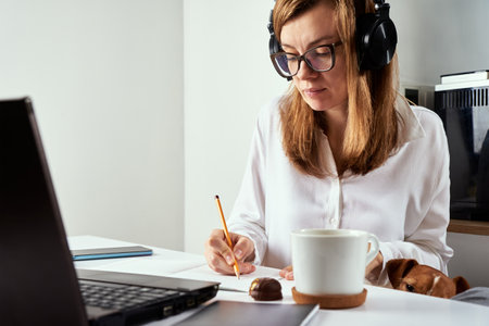 Remote work. Online courses, distance education and e-learning concept. Woman in headphones listen...