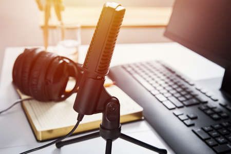 Microphone, headphones and computer monitor on the table. Online podcast conceptの写真素材