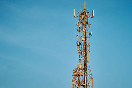 Communication tower with antenna against blue skyの写真素材