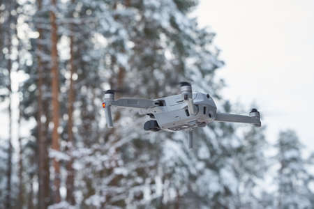 Drone quadcopter with camera flying in the winter forestの写真素材