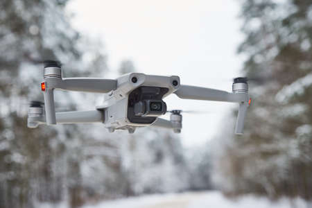 Drone quadcopter with camera flying in the winter forestの写真素材