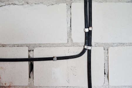 Electrical wires on a brick wall. Cable layingの写真素材