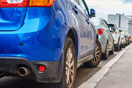 Parked cars along the sidewalk on city streetの写真素材