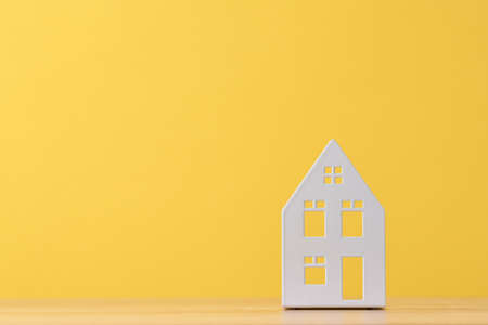 Figure of toy house on yellow background with copy spaceの写真素材