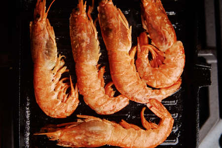 Grilled large shrimps with lemon and spices on grill panの写真素材