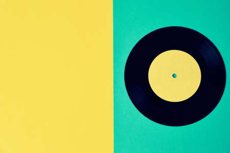 Old retro vinyl disc on colored background. Vintage toned photoの写真素材